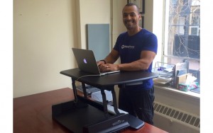 Above: Brent Bishop at his home office with his adjustable stand-up desk from Varidesk