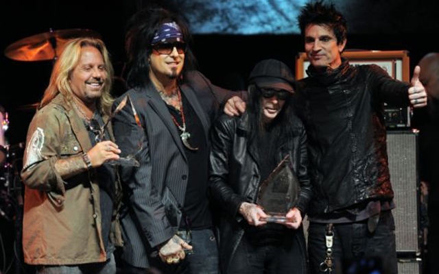 Above: Vince Neil, Nikki Sixx, Mick Mars and Tommy Lee pose together onstage at a tribute to the band in West Hollywood, California