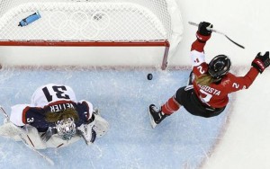 Above: Meghan Agosta-Marciano of Canada celebrates her goal as USA Goalkeeper Jessie Vetter looks down at the ice in the third period